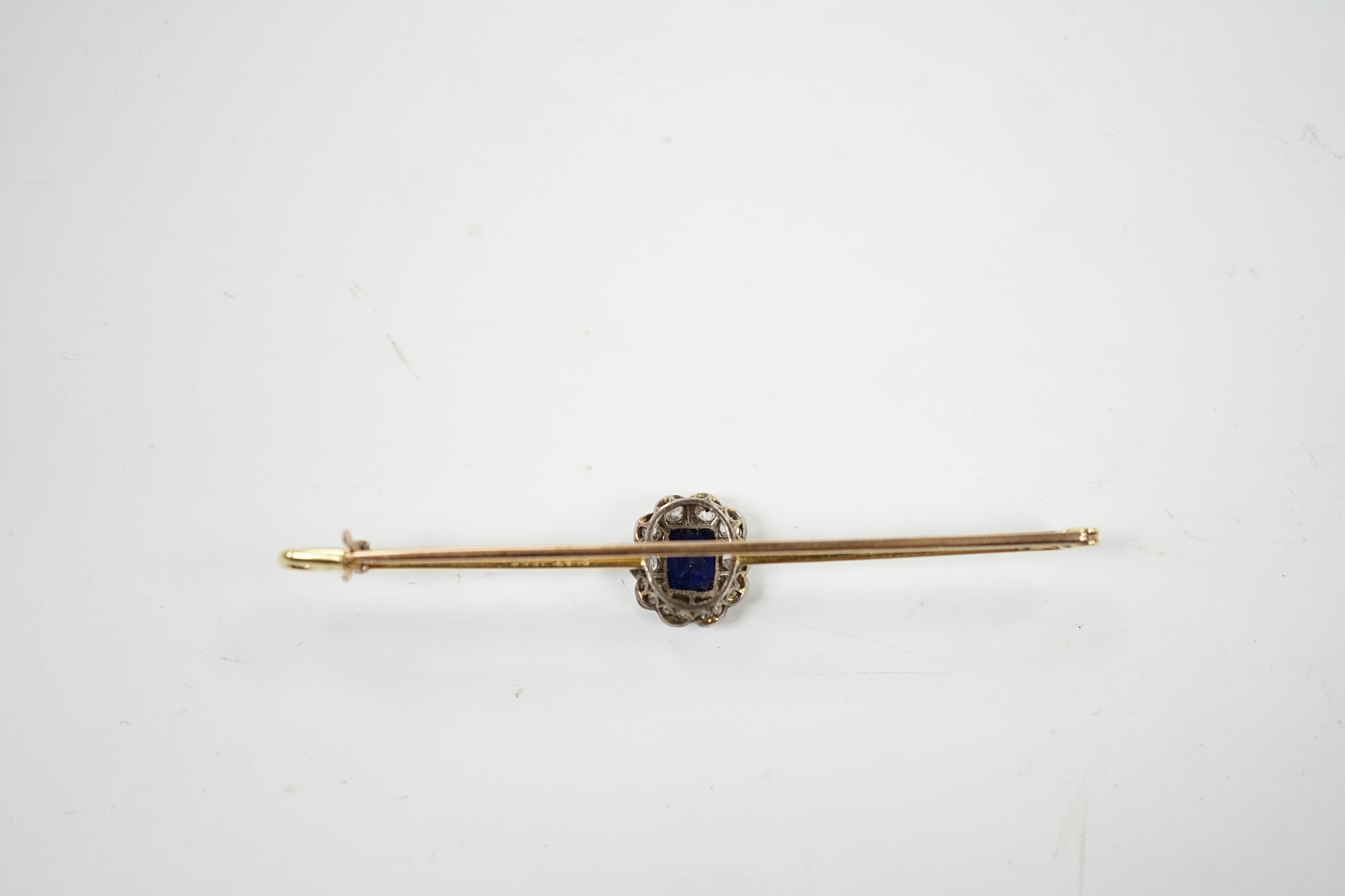 An early 20th century 15ct and plat, sapphire and diamond oval cluster set bar brooch, 64mm, gross weight 4.1 grams.